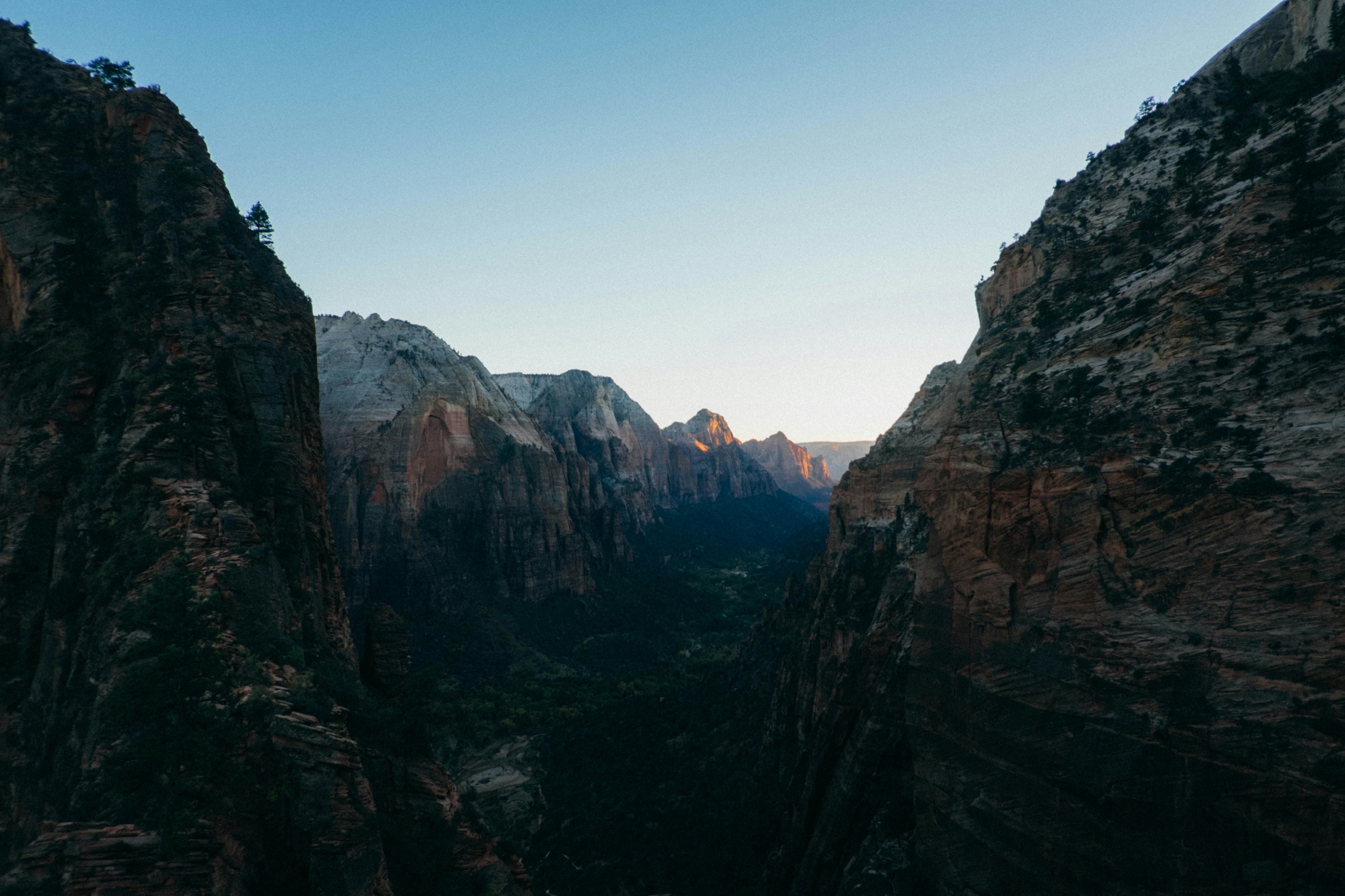 Canyon walls framing a valley at sunset