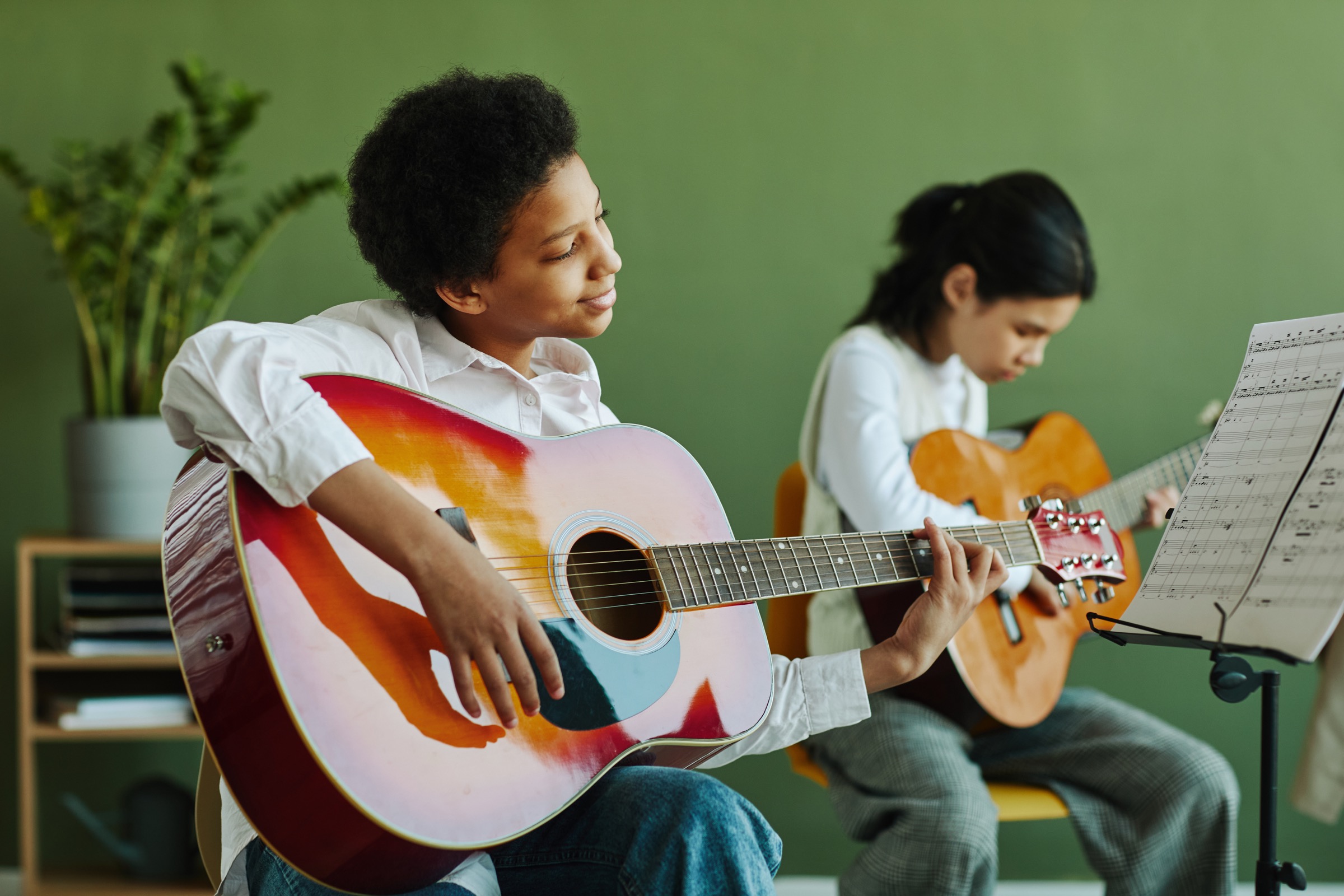 Two musicians playing acoustic guitars together